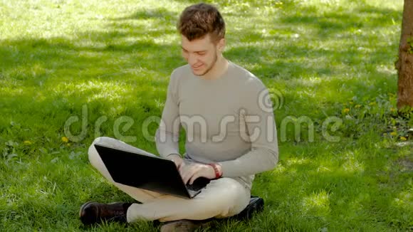 疲惫的人在公园里用笔记本电脑工作而不是走开视频的预览图