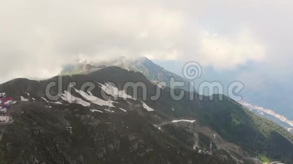 相机飞过群山艾布拉岭雪背景上有小屋的缆车滑雪场附近的山脉视频的预览图