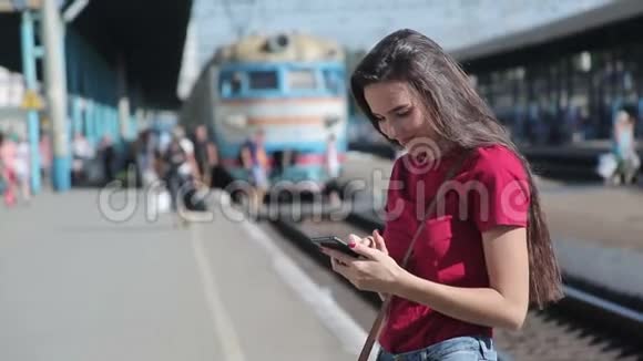 火车站使用智能手机的年轻女子视频的预览图