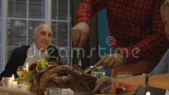 在感恩节晚餐上雕刻火鸡的人视频的预览图