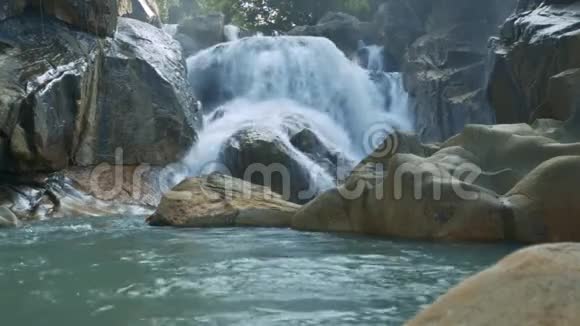小泡沫瀑布在岩石中流入湖中视频的预览图
