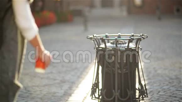 女人扔空纸咖啡杯附近回收站城市背景回收利用生态友好办法概念视频的预览图