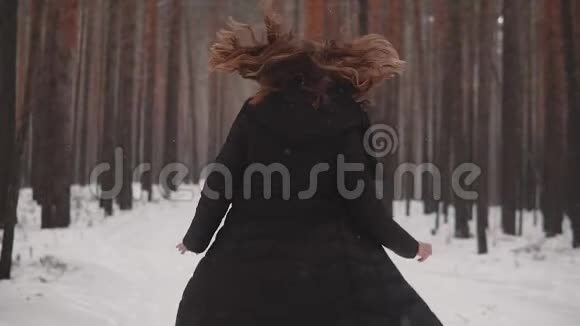 一个红发女孩在冬天的森林里出现精灵的肖像女孩穿过冬天的森林看上去视频的预览图