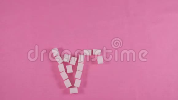一颗有龋齿的不健康的牙齿在粉红色的背景上内衬精制的糖块视频的预览图