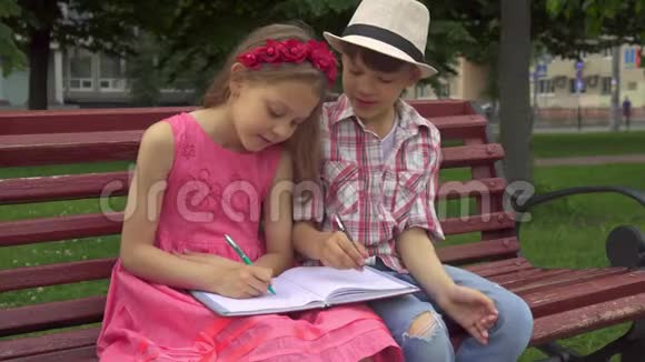 小女孩在一页笔记本上画画她的朋友在另一页笔记本上画画视频的预览图