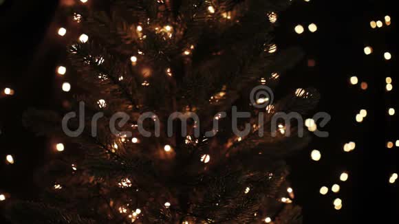 女性装饰圣诞树用金色的星星装饰在boke灯光背景上视频的预览图