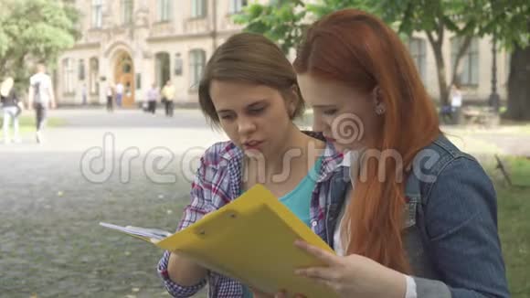女学生在校园里看一些日记视频的预览图