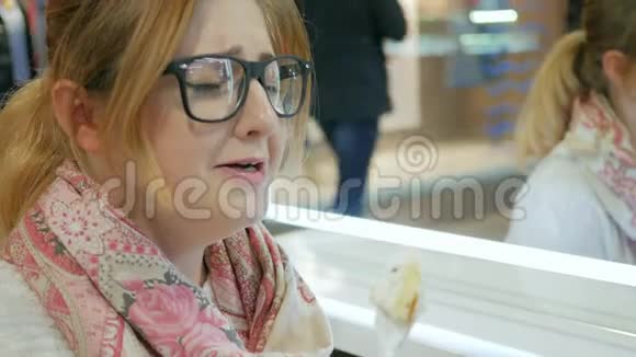 胖女人断了饮食大口大口地吃着甜的不开心的女人正在吃面包店哭着这是一个享受新鲜的女孩的特写镜头视频的预览图