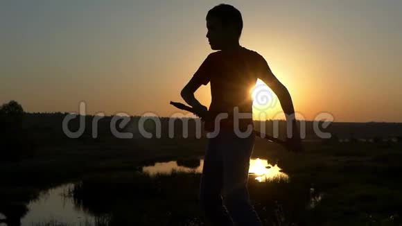 斯隆莫的小男孩火车在秋天的日落时用棍子吹功夫视频的预览图