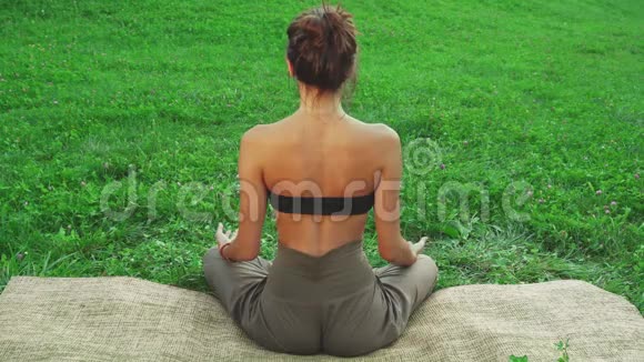女孩坐在瑜伽垫上做一个瑜伽姿势视频的预览图