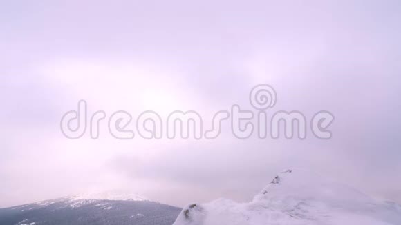 一个年轻人一个游客站在一座白雪覆盖的山的边缘欣赏山顶视频的预览图