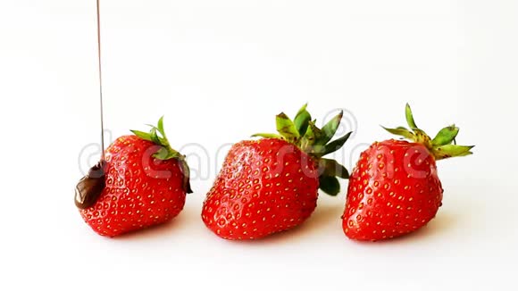 三个成熟的草莓上面浇上融化的巧克力视频的预览图