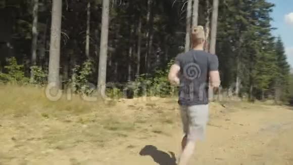 阳光明媚的白天英俊的白种人在森林里奔跑视频的预览图