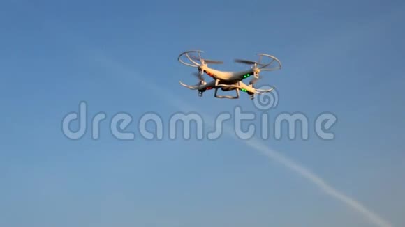 小白色玩具无人机飞行在下午落日落树上视频的预览图