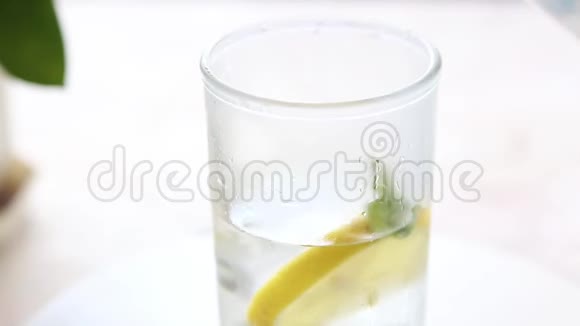 在白桌子上倒一杯柠檬冰块和薄荷水视频的预览图
