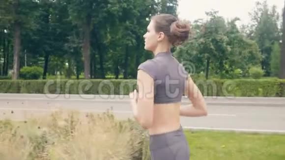 年轻运动员女子在夏季公园晨练跑步视频的预览图