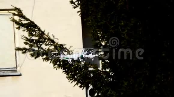小型白色玩具无人机与相机混乱地飞行在居民住宅前视频的预览图