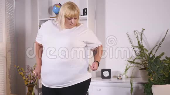 胖女人测量腰部悲伤视频的预览图