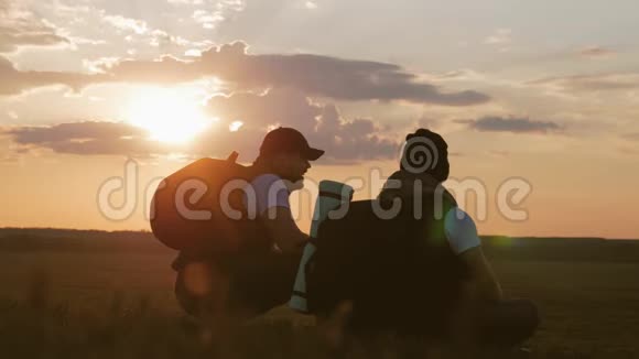 两个人在山顶上的剪影背包和其他齿轮表达能量和幸福二视频的预览图