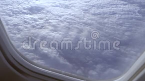 透过一架飞行飞机舷窗的玻璃观看云层视频的预览图