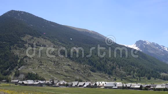 滑翔伞飞过群山令人惊叹的法国阿尔卑斯山夏天的背景视频的预览图