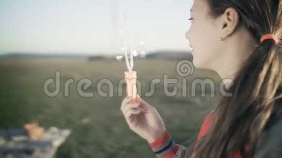 一个漂亮的年轻女孩在空旷的草地上吹肥皂泡视频的预览图