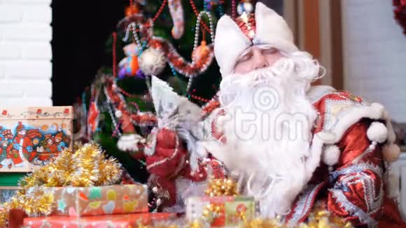 圣诞老人圣诞老人弗罗斯特神父正拿着一把美元的扇子扇着自己他坐在一张桌子旁坐在桌子旁视频的预览图