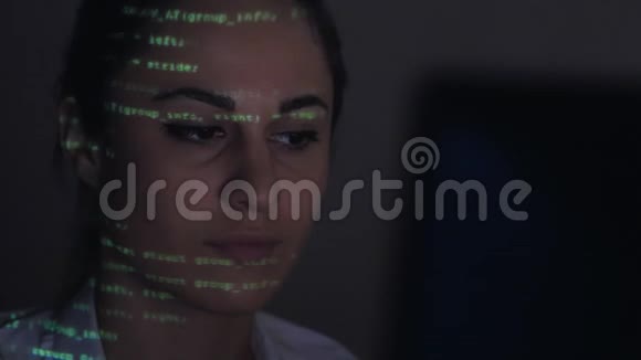 年轻女性擦洗槽电脑代码双码投影女性面部视频的预览图