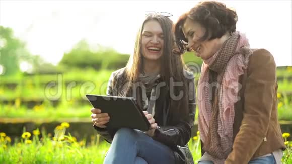 怀着白牙的快乐女人手里拿着平板在笑可爱的布鲁尼茨和视频的预览图