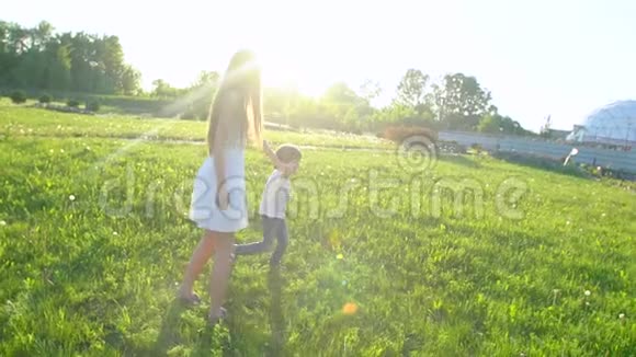 家庭在户外快乐母子小男孩在太阳日跑步享受大自然的夏天妈妈和孩子可爱的男孩视频的预览图