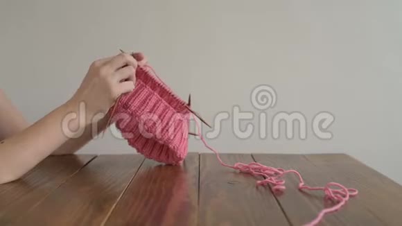 女手编织一顶粉红色的帽子视频的预览图
