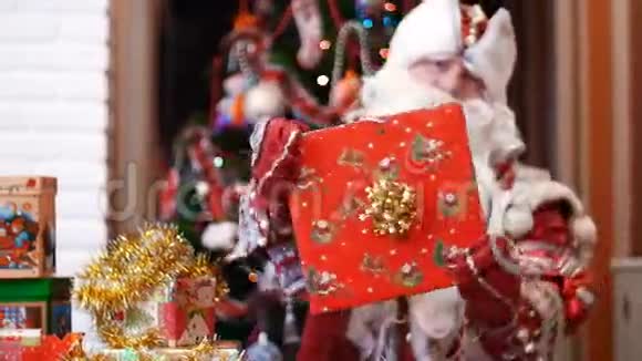 圣诞老人弗罗斯特神父手里拿着一件红色纸纸包装的圣诞礼物视频的预览图