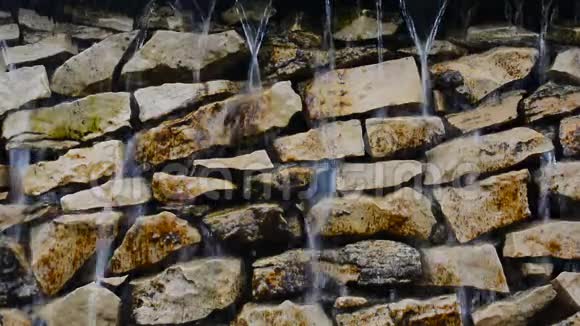 瀑布滴落顺流而下的岩壁特写视频的预览图