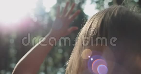 年轻女子举起手来晒太阳视频的预览图