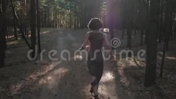 有魅力的女孩穿着裙子在树林里奔跑视频的预览图