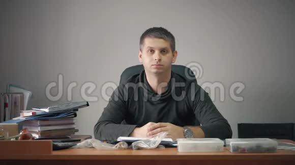 快乐的年轻商人坐在办公室桌上有商业文件帅哥在工作在家写字视频的预览图