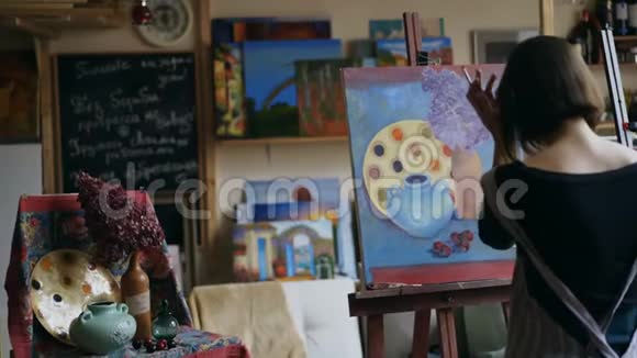 青年女画家围裙油画油画油画静物画的后视图视频的预览图