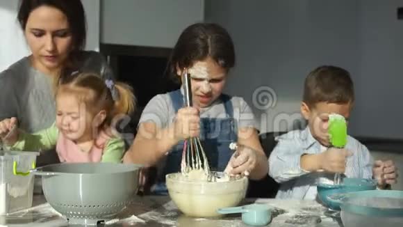 一位带着三个孩子的年轻母亲为饺子和馄饨准备面团斯拉夫菜俄罗斯菜视频的预览图