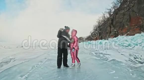 在冰封的湖面上年轻夫妇在冬天散步时玩得很开心爱情故事恋人们留着浮冰视频的预览图