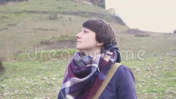 一位年轻女子在山景和古城背景下的肖像视频的预览图