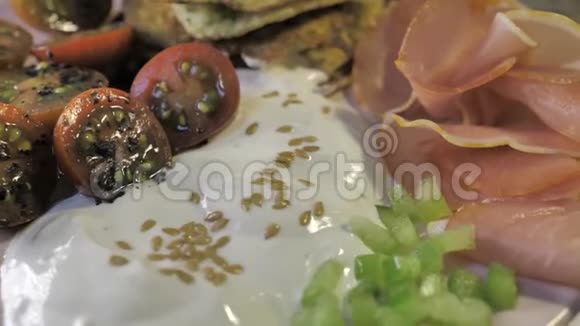 准备好的餐盘西葫芦煎饼番茄樱桃意大利火腿芝麻白奶油视频的预览图
