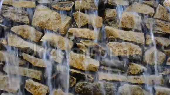 瀑布滴落顺流而下的岩壁特写视频的预览图