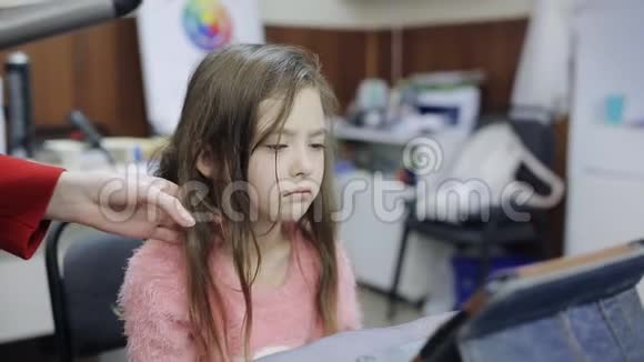 理发师让发型悲伤的女孩看着平板电脑视频的预览图