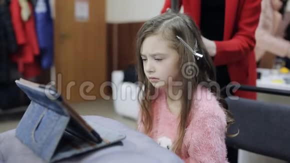 理发师让发型悲伤的女孩看着平板电脑视频的预览图
