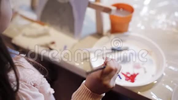 一个小女孩正在画布上画一幅画美术学院桌面画架和丙烯酸涂料视频的预览图