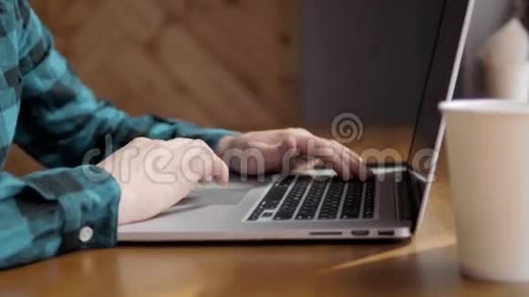 在办公室里用笔记本电脑特写男性的手在咖啡馆旁商人的手在笔记本键盘上打字视频的预览图