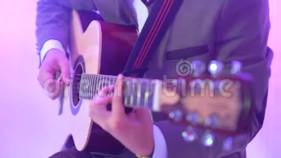 4k吉他手在夜总会舞台上弹声吉他彩灯闪烁视频的预览图