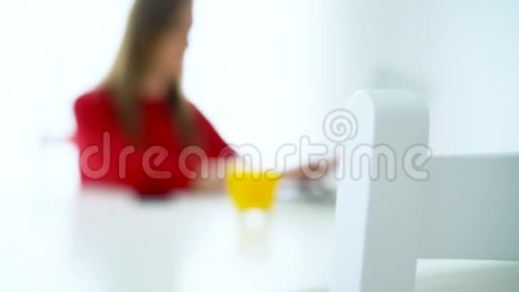 微笑的女人坐在白色的家庭办公室用笔记本电脑工作视频的预览图