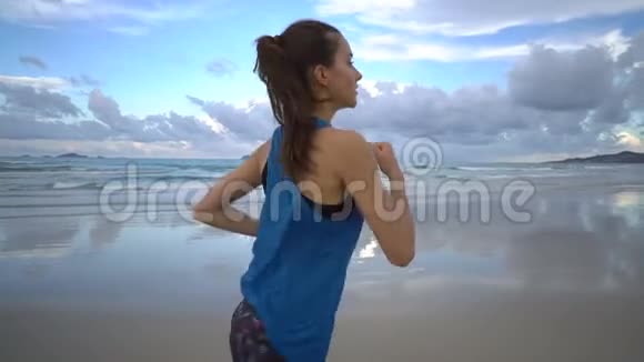 在日落时分健康活跃有魅力的女人开始在海边慢跑视频的预览图
