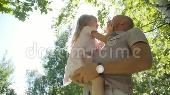 快乐的父亲在公园里拥抱和摆动他的女儿慢动作视频的预览图